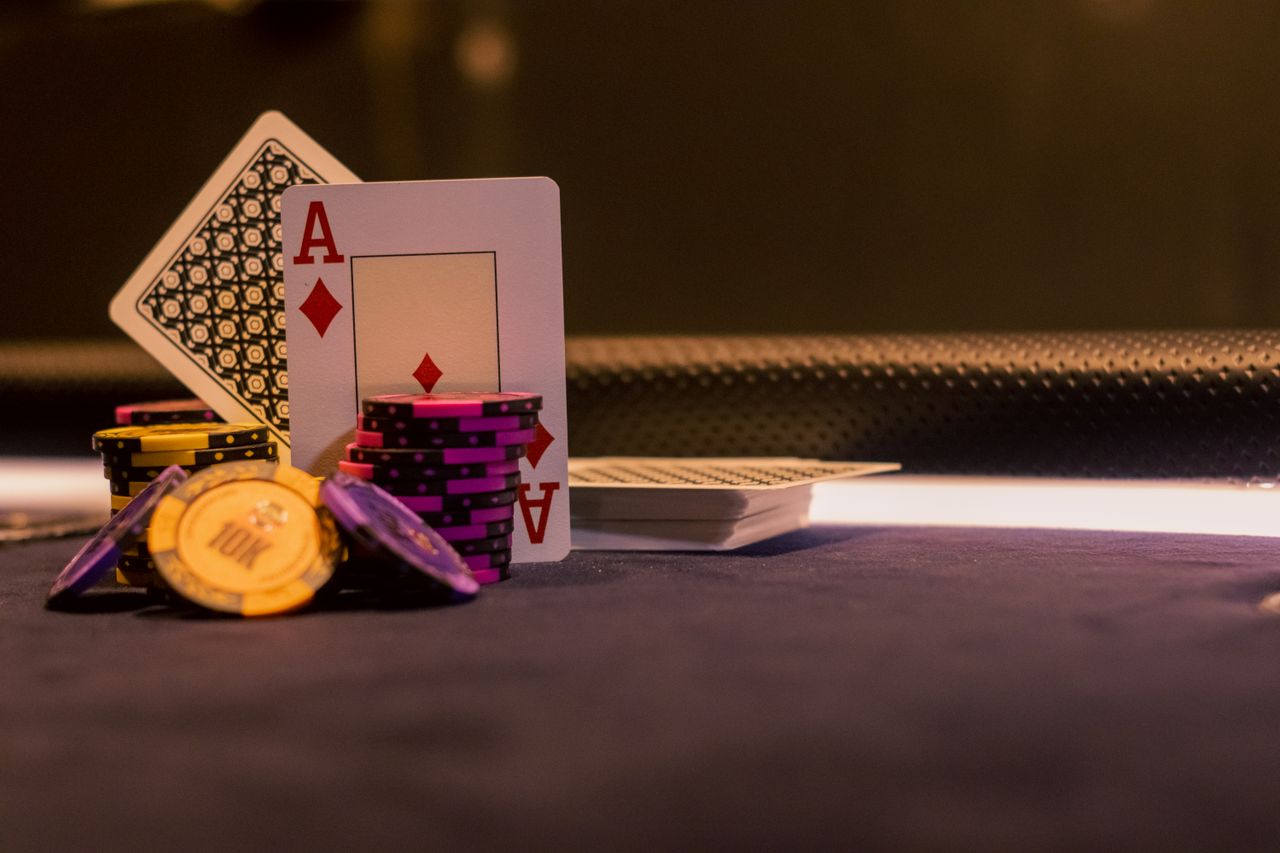 ours-journey A close-up of poker chips and playing cards on a casino gaming table, highlighting Ace of Diamonds.
