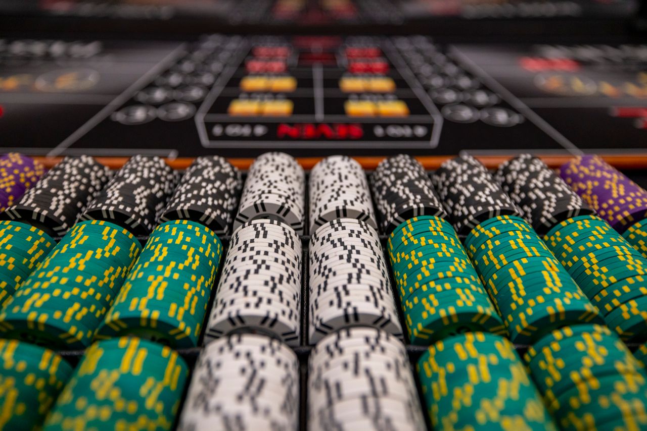 gallery-5 Close-up of colorful casino chips arranged on a gaming table, ready for play.