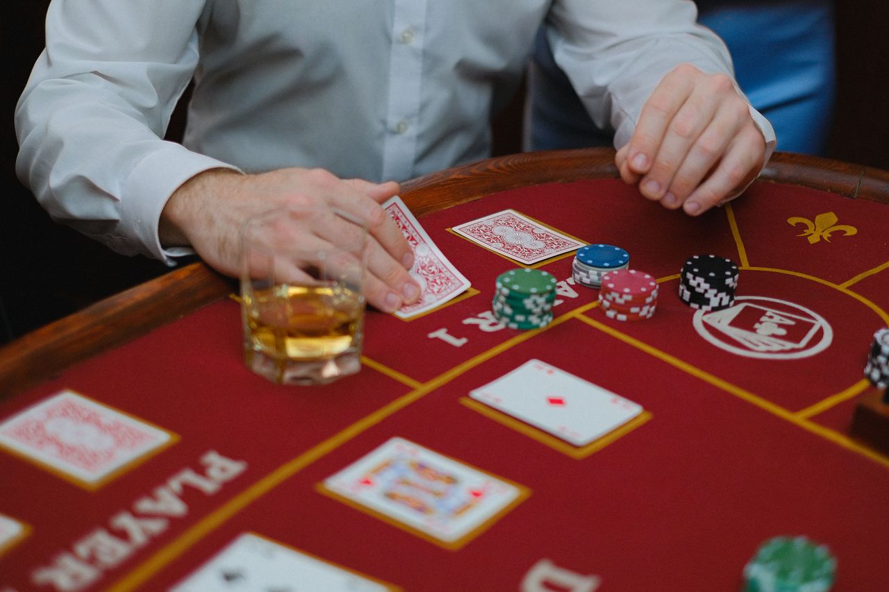 gallery-3 Intense poker game with cards and chips on a red casino table, creating a thrilling atmosphere.