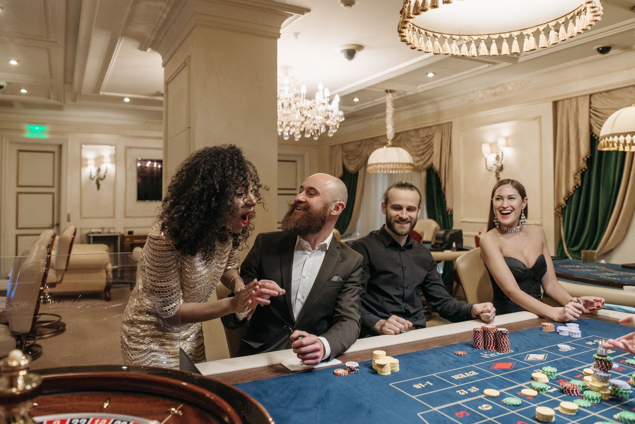 hero-img-02 Group of adults enjoying a lively night at a casino poker table, gambling with friends.